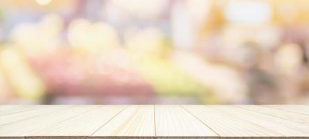 Wood table top with supermarket grocery store blurred background with bokeh light for product display photo