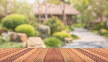 Empty wood table top with abstract blur park garden background photo