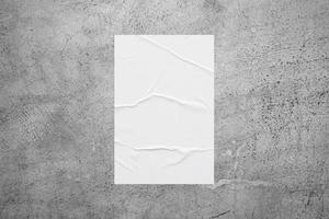 Blank white wheatpaste glued paper poster mockup on concrete wall background photo