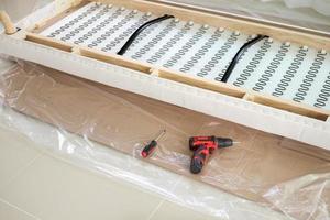 assembling sofa furniture at home with cordless screwdriver photo