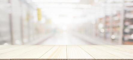 Wood table top with supermarket grocery store blurred background with bokeh light for product display photo