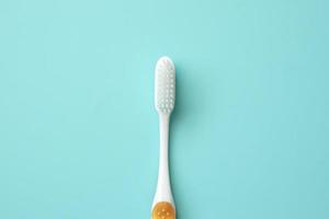 Toothbrush on blue background top view close up photo