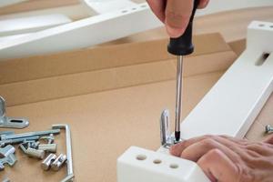 Assembly furniture using screwdriver at home photo