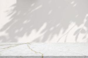 Marble table with tree shadow drop on white wall background for mockup product display photo