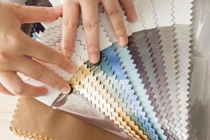 female designer with fabric color samples choosing textile for curtains photo