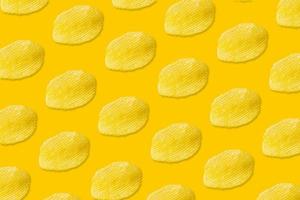 Potato chips pattern on yellow background top view flat lay photo