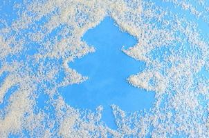 Christmas blue background with coconut chips, a place to record in the form of a Christmas tree photo