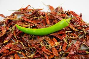 dried red pepper and one fresh green photo