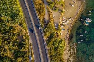 Aerial.road and Waves float to the rocky shore. photo