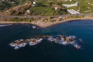 from the air. Waves float to the rocky shore. photo