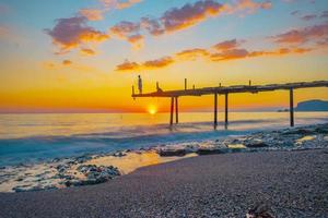 View of a rocky coast in sunset. Sunset sea rock landscape in Long exposure shot photo