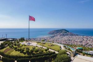 Alanya top view on the mountain with turkey flag and city background  Beautiful Alanya Turkey landscape travel landmark photo