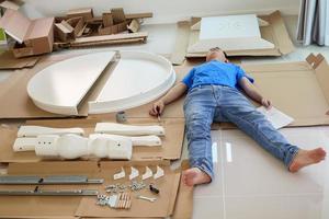 Man assembling white round table furniture at home photo