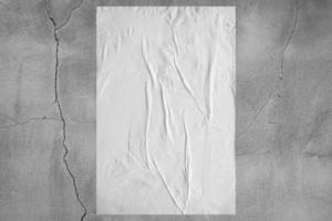 Blank white wheatpaste glued paper poster mockup on concrete wall background photo