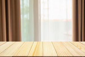 Empty wood table top with window curtain abstract blur background for product display photo