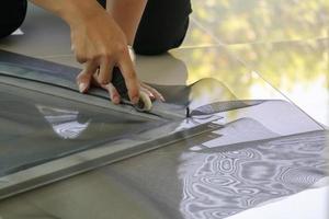 man install mosquito net wire screen on house window protection against insect photo