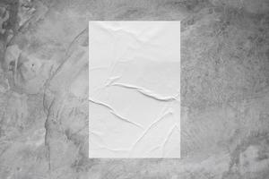 Blank white wheatpaste glued paper poster mockup on concrete wall background photo