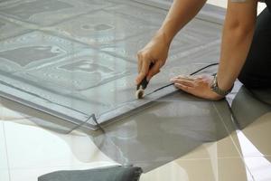 man install mosquito net wire screen on house window protection against insect photo