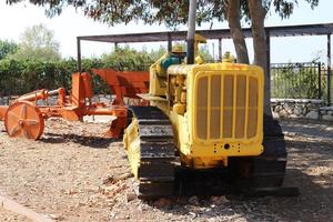 Old agricultural machinery stands on the street in Israel and rusts photo