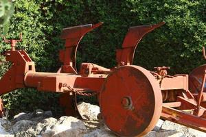 Old agricultural machinery stands on the street in Israel and rusts photo