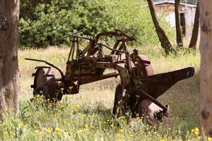 Old agricultural machinery stands on the street in Israel and rusts photo