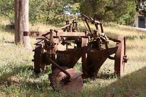 Old agricultural machinery stands on the street in Israel and rusts photo