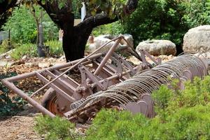 Old agricultural machinery stands on the street in Israel and rusts photo