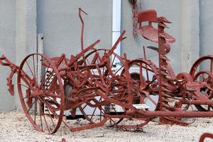 Old agricultural machinery stands on the street in Israel and rusts photo