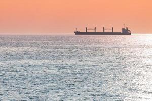 Barge at beautiful sunset. Anchorage for ships, copy space. Amazing evening seascape, breathtaking travel view. photo