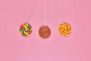 Sweet lollipops on pink background photo