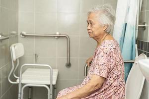 Asian senior or elderly old lady woman patient use toilet bathroom handle security in nursing hospital ward, healthy strong medical concept. photo