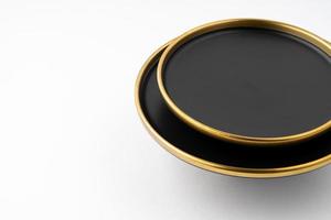 A set of black and golden ceramic plates on a white background photo