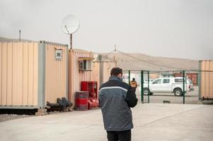 A rear view of male walking by accommodation containers photo