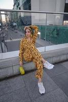 A portrait of a fashion-dressed happy woman posing for a photo shoot on the streets