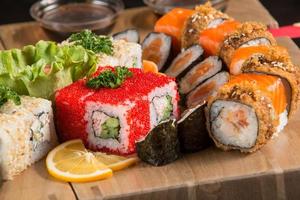 A closeup shot of a sushi set on a wooden plate photo