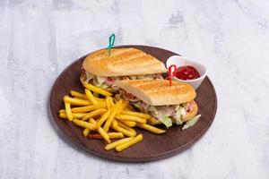 A plate of fries and a chicken sandwich with ketchup isolated on a bright background photo