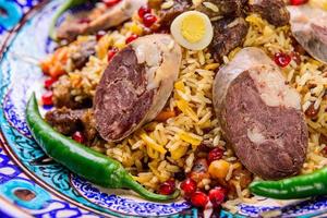 A closeup of an appetizing Uzbek national dish Plov, Pilaf made of rice and meat served with peppers photo