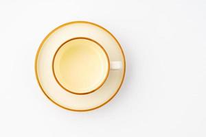 A set of white and brown ceramic plate and cup on a white background. Top view photo