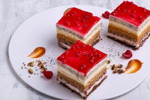 An appetizing dessert with slices of cakes with raspberry and nuts photo