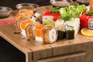 A closeup shot of a sushi set on a wooden plate photo