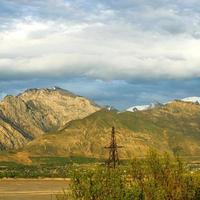 A vertical shot of mountains against the background of the cloudy sky. Central Asia photo