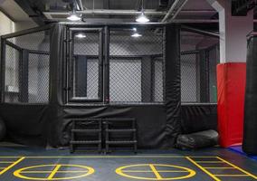 An octagonal kickboxing cage with boxing bags in the sports complex photo