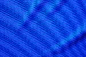 Blue football jersey clothing fabric texture sports wear background, close up top view photo