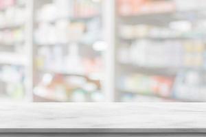 Empty white marble counter top with blur pharmacy drugstore shelves background photo