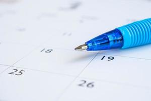 bolígrafo azul en el fondo de la página del calendario concepto de reunión de cita de planificación empresarial foto