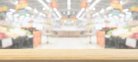 Wood table top with supermarket grocery store blurred defocused background with bokeh light for product display photo