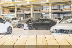 Empty wood table top with car service centre auto repair workshop blurred background photo