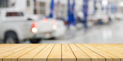 Empty wood table top with car service centre auto repair workshop blurred background photo