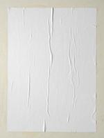 Blank white wheatpaste glued paper poster mockup on white wall background photo