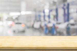 Empty wood table top with car service centre auto repair workshop blurred background photo